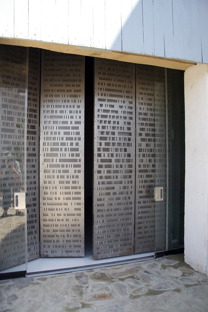 Perforated steel screens sliding in the shed opening