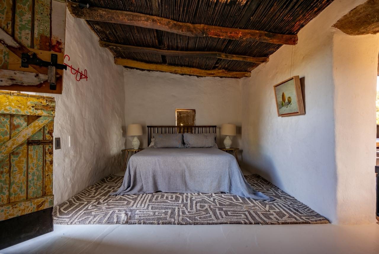 Skaapwagtershuisie — bedroom in original stone cottage, reed ceiling, whitewashed walls