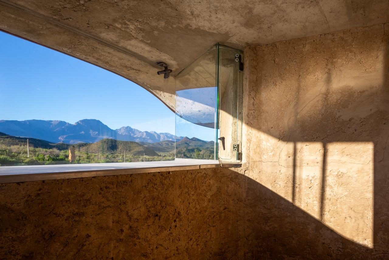 Skaapwagtershuisie — interior window onto Towerkop, poured earth walls, concrete ceiling