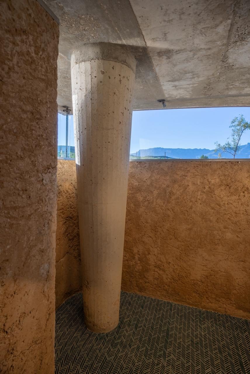 Skaapwagtershuisie — poured earth wall, concrete column, mountain strip window