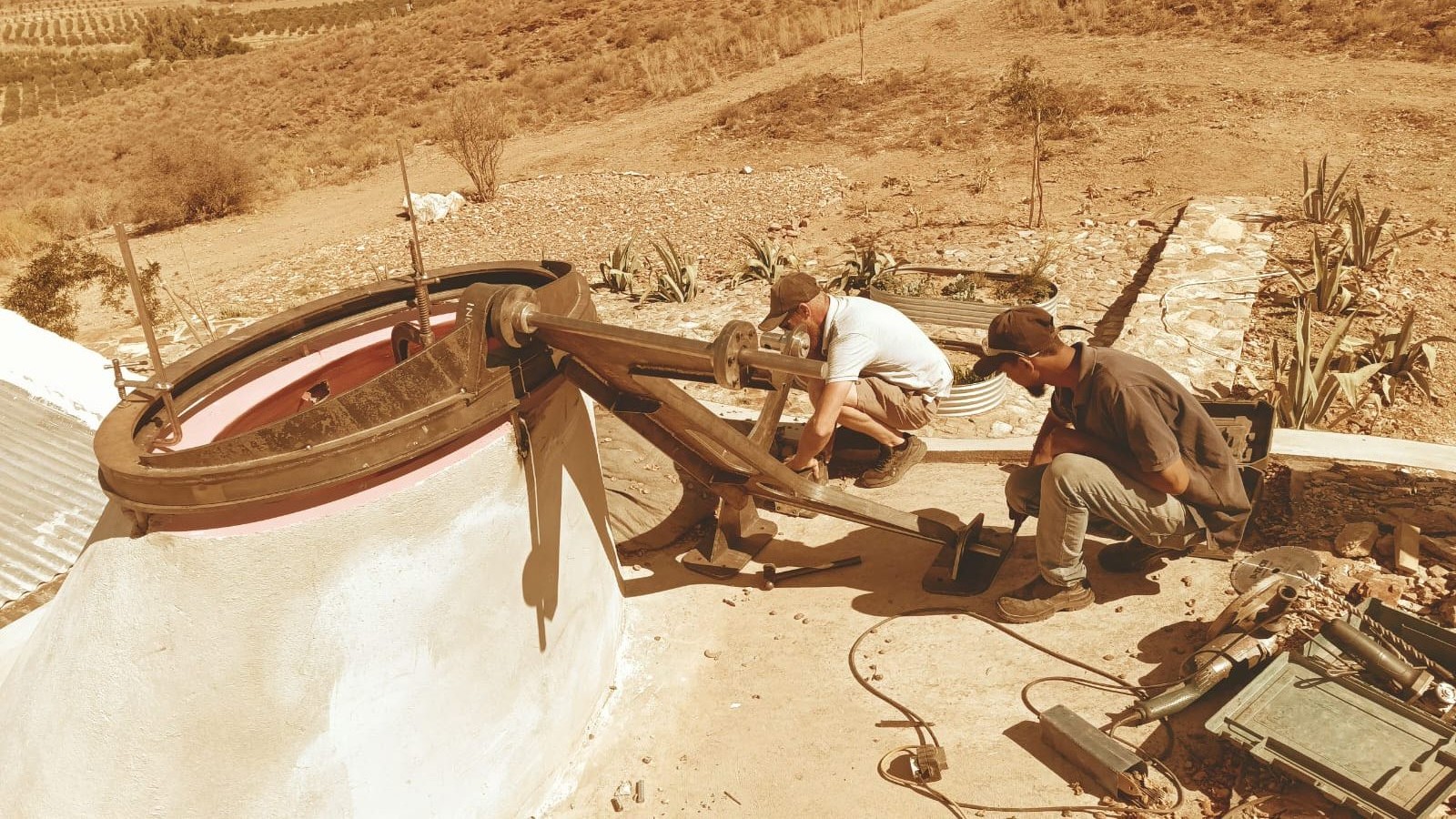 Glass-lifting machine — elliptical counterweighted jig on the tank, Karoo veld