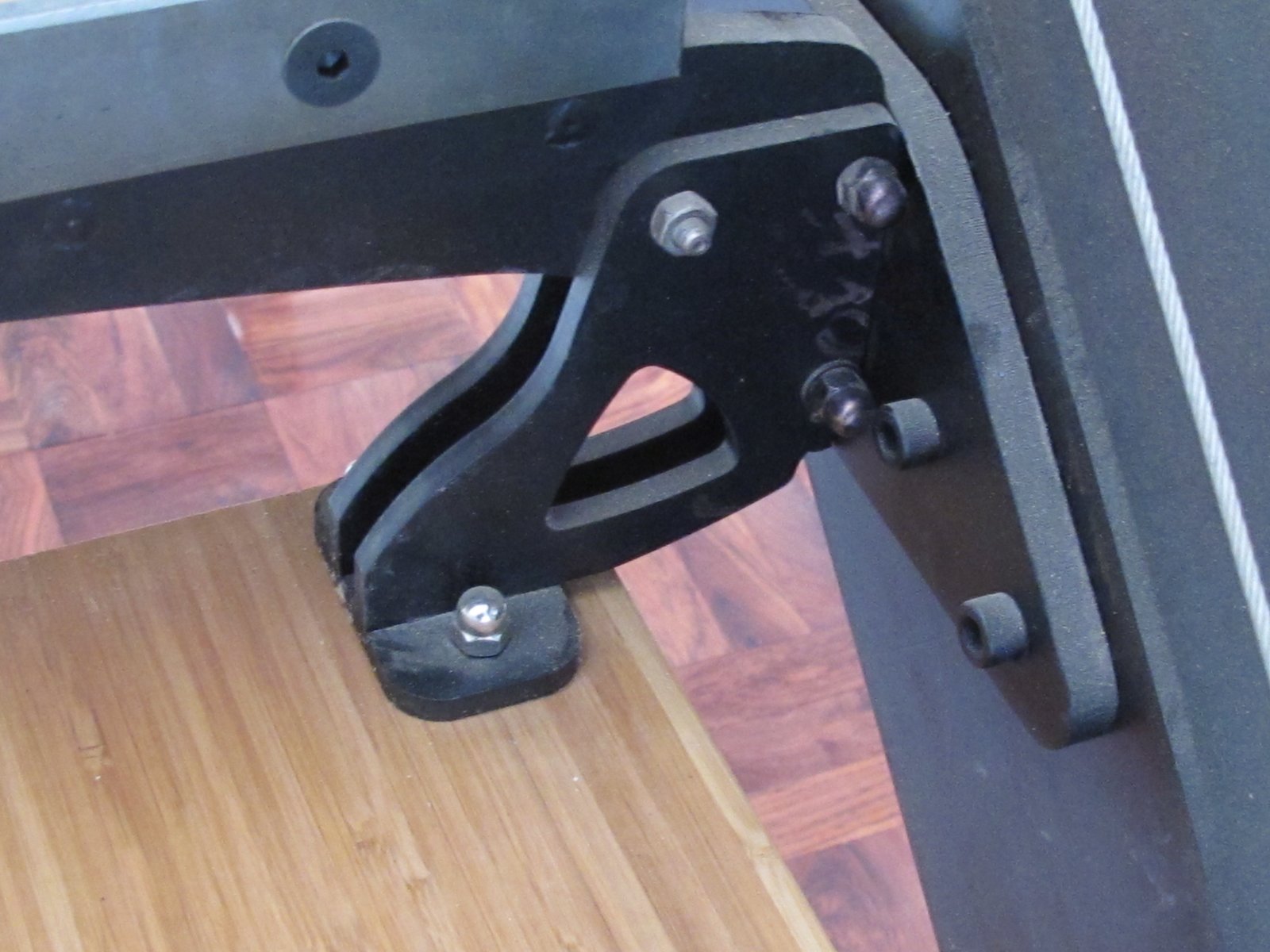 Machined steel bracket bolted to a bamboo plywood tread